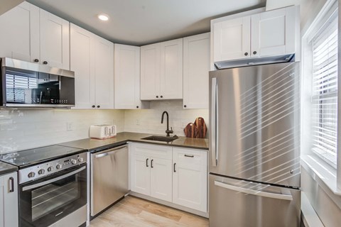 a kitchen with stainless steel appliances and white cabinets